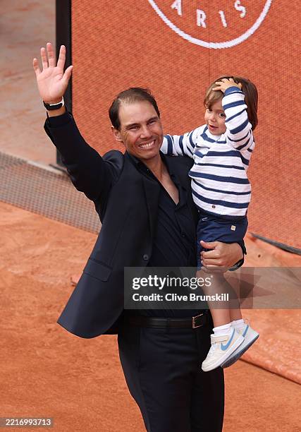 Rafael Nadal carries his son Rafael out on to Court Philippe-Chatrier during a ceremony held in his honour on Day One of the 2025 French Open at...