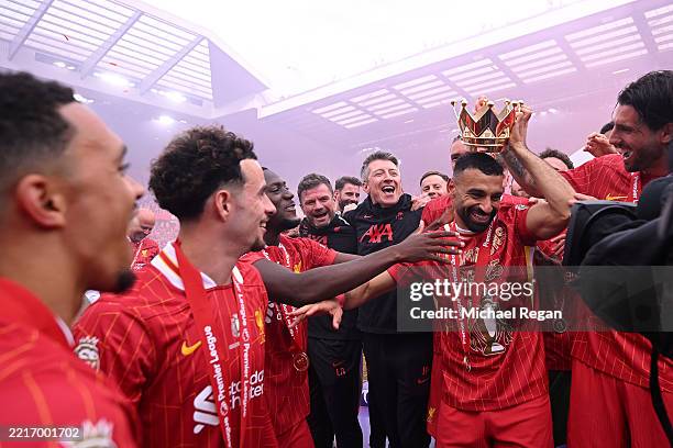 Mohamed Salah of Liverpool has the lid from Premier League trophy placed on his head as he celebrates with teammates as Liverpool are crowned the...
