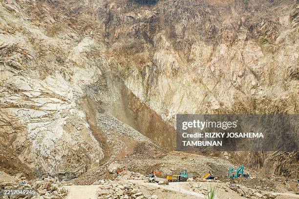 Rescuers use heavy equipment to search for landslide victims buried under rocks at the C excavation site in Cipanas, Dukupuntang, Cirebon Regency,...