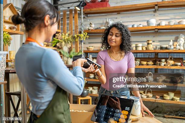 customer paying with nfc technology in a ceramic shop - credit card art stock pictures, royalty-free photos & images
