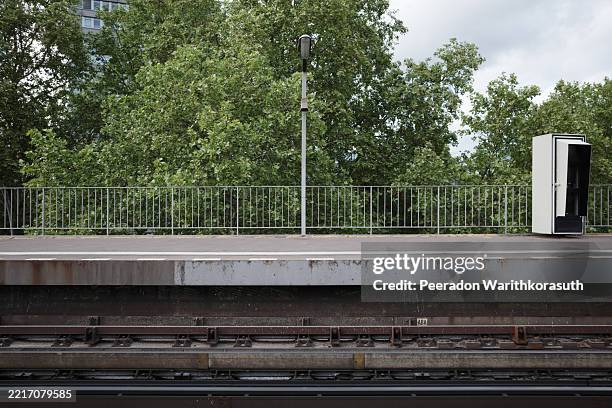 empty train platform with trees and track view - andén de estación de tren fotografías e imágenes de stock