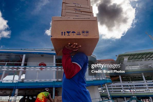 Dockworkers load diverse merchandise onto traditional Amazon Dockworkers load diverse merchandise onto traditional Amazon