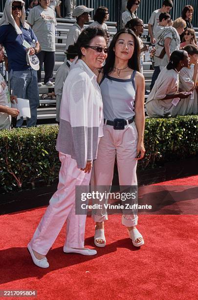American actress Ming-Na Wen, wearing a blue vest with dark blue trim and white trousers, with her mother Lin Chan Wen, at the premiere of Walt...