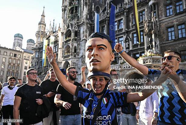 An Inter Milan supporter wearing a hat featuring Inter Milan's Argentine forward Lautaro Martinez cheers on the eve of the UEFA Champions League...