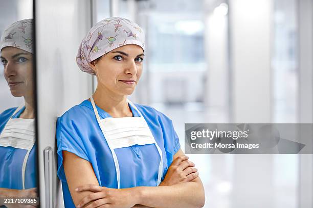 confident female doctor in corridor of hospital - medical scrubs stock pictures, royalty-free photos & images