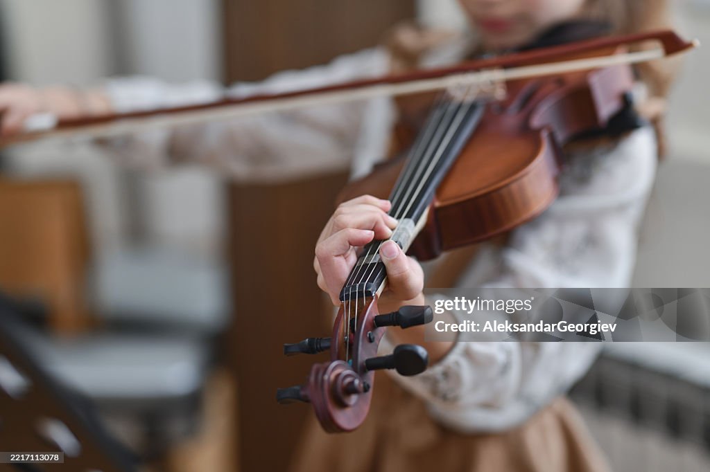 Fokussierte junge Geigerin, die in ihre Musik vertieft ist und Emotionen in jede Note einfließen lässt