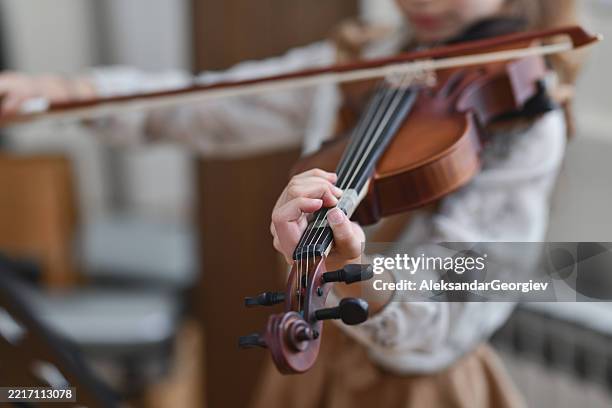 focused young violinist immersed in her music pouring emotion into every note - musical instrument string stock pictures, royalty-free photos & images