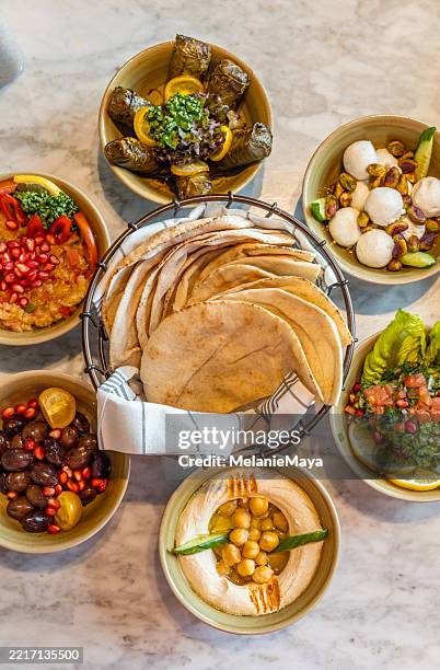 apéritif arabe meze variété de plats avec houmous, moutabel, labenah, feuilles de vigne pour un repas gastronomique du moyen-orient servi sur la table du déjeuner - stylisme culinaire photos et images de collection