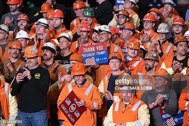 Steel worker holds a sign as US President Donald Trump speaks during a visit to US Steel - Irvin Works in West Mifflin, Pennsylvania, May 30 to mark...