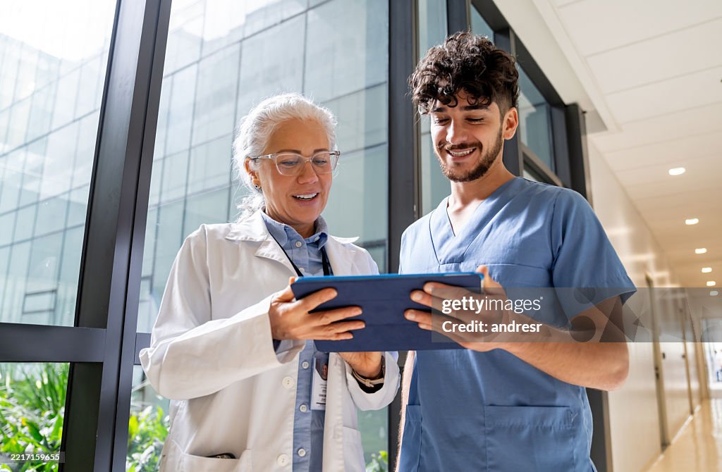 Doctor discussing test results with nurse using a digital tablet