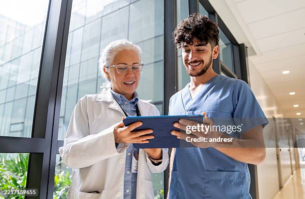 doctor discussing test results with nurse using a digital tablet - estudante de medicina imagens e fotografias de stock