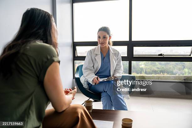 médico hablando con un paciente en una consulta en el hospital - salud mental fotografías e imágenes de stock