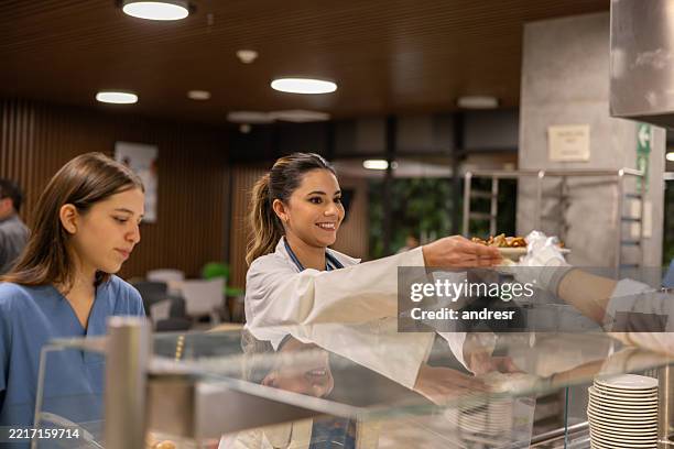 happy doctor having lunch in the hospital's cafeteria - cantina imagens e fotografias de stock