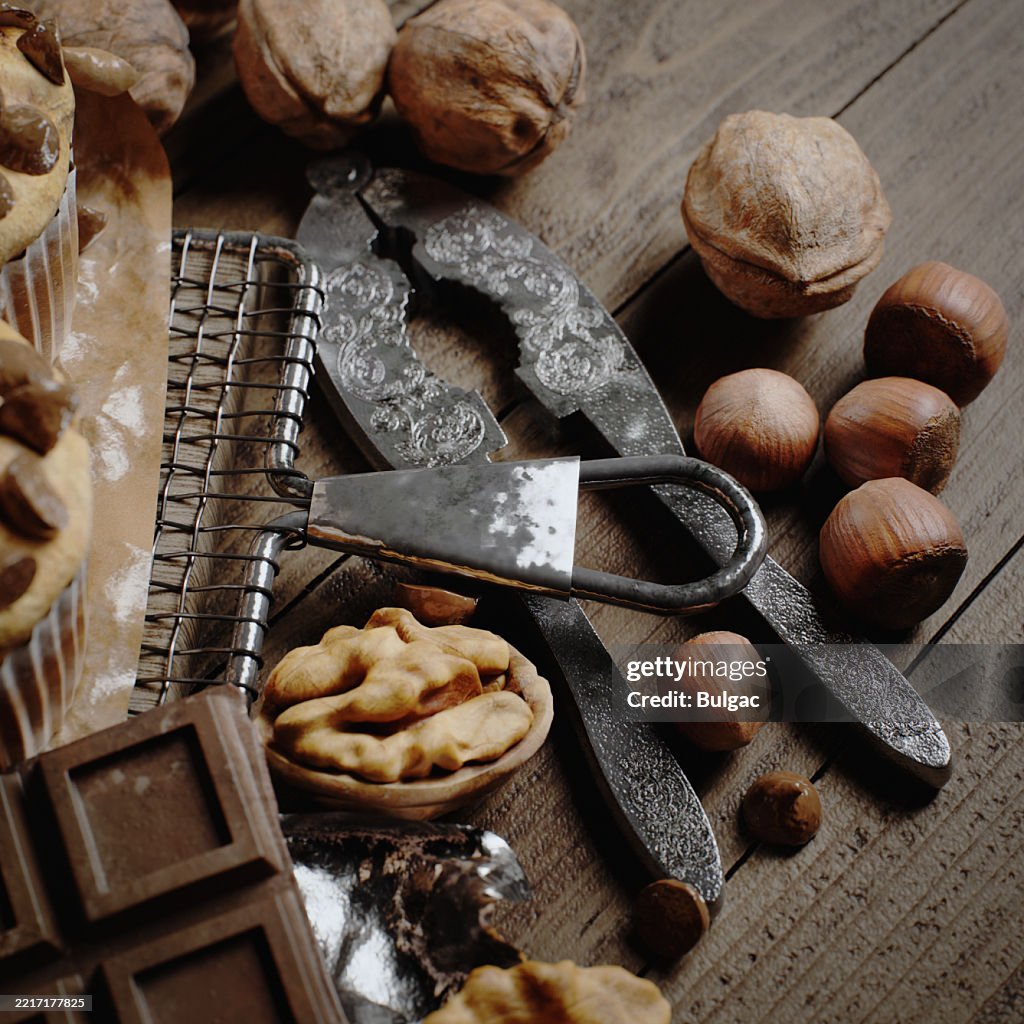 Assorted Nuts with Antique Nutcracker on Rustic Wooden Table and Chocolate Pieces