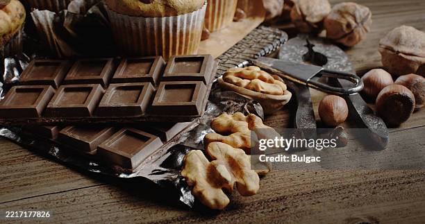 close-up of a rustic chocolate, nut, and dessert assortment on wooden table - avelã imagens e fotografias de stock