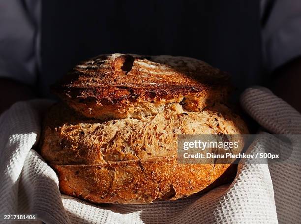 midsection of teenager holding fresh bread in kitchen at home - sourdough bread stock pictures, royalty-free photos & images