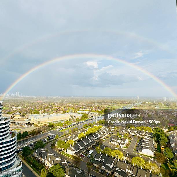 high angle view of rainbow over buildings in city,mississauga,ontario,canada - dewan stock pictures, royalty-free photos & images