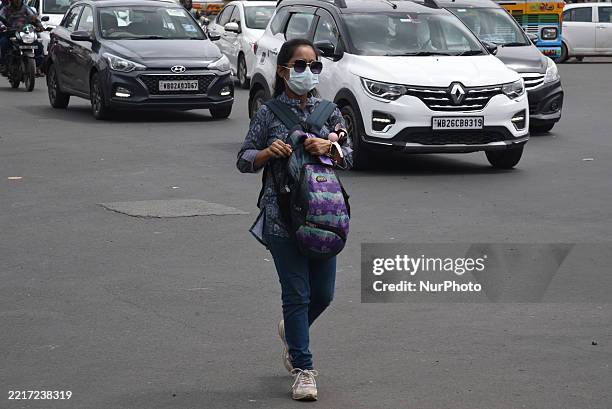 An Indian young girl wears a surgical face mask and walks on a busy street in Kolkata, India, on May 30, 2025. India's active Covid-19 cases climb to...