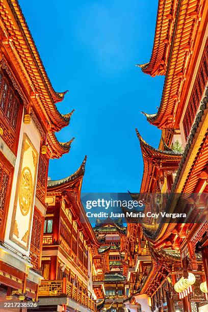 striking view of traditional chinese architecture with their illuminated red walls create a stunning scene at the yu yuan gardens in shanghai, showcasing the city's architectural elegance at twilight. shanghai, china - shanghai stock pictures, royalty-free photos & images