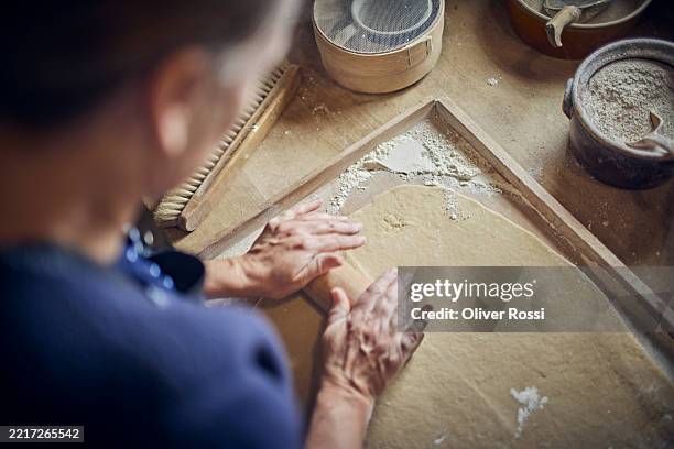 woman making dough using rolling pin - tradizione foto e immagini stock