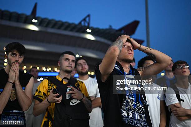 Inter fans react after PSG scored their second goal as they watch outside the San Siro stadium the UEFA Champions League final football match between...