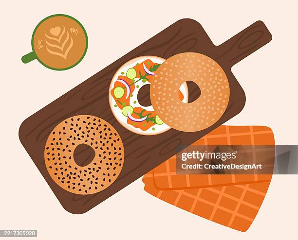 high angle view of table with smoked salmon bagels on cutting board and a cup of coffee - bagel and cream cheese overhead stock illustrations