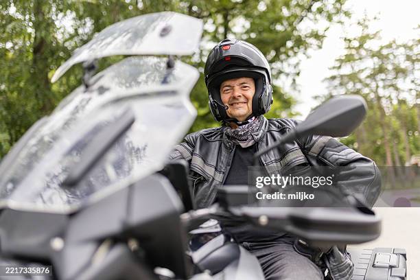a man is sitting on his motorcycle on road - leisure equipment stock pictures, royalty-free photos & images