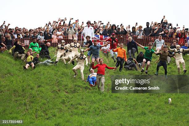 Tom Kopke from Germany chases the cheese down the hill in the first mens downhill race during Gloucestershire's famous Cheese-Rolling contest on May...