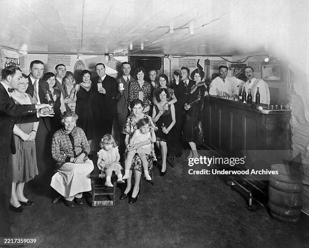 Group portrait of people of a variety of ages, including several children, as they pose in Jimmy Brennan's bar, San Francisco, California, May 21,...