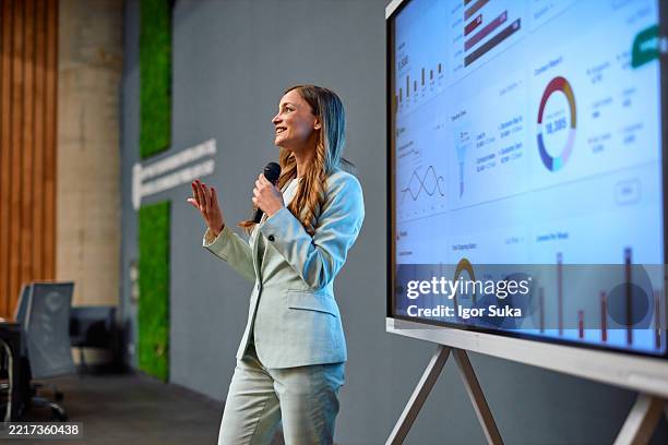 businesswoman presenting marketing data using interactive whiteboard during a conference - presentation speech stock pictures, royalty-free photos & images