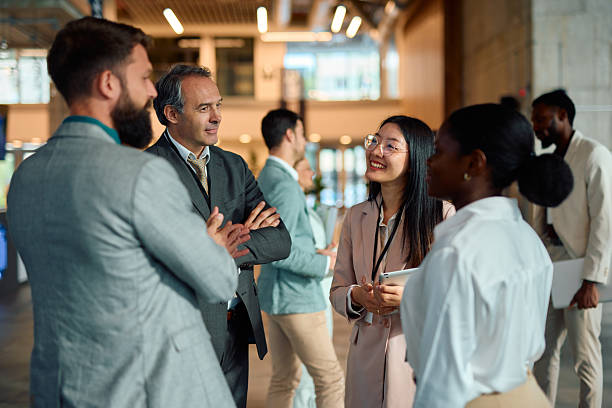 businesspeople networking and discussing during a corporate event - global skills stock pictures, royalty-free photos & images