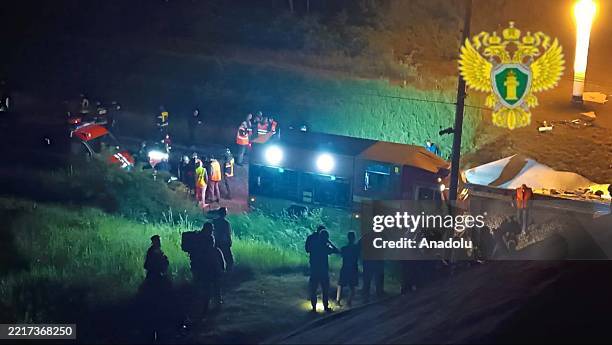 Rescue teams continue to examine damaged carriages and the locomotive of the train after a road bridge collapsed and the subsequent derailment of a...