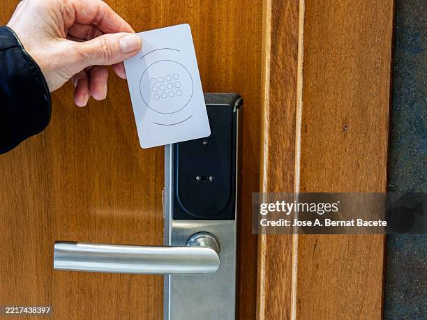 female hand inserting a key card into the lock of a hotel room door - hotel key stock pictures, royalty-free photos & images
