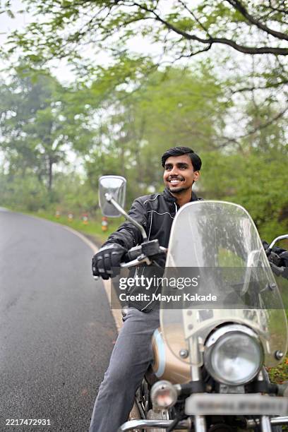 young man on a motorcycle on a scenic countryside road - monsoon stock pictures, royalty-free photos & images