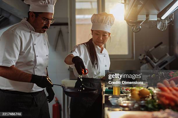 chefs preparing ingredients in a professional kitchen - chef precision stock pictures, royalty-free photos & images