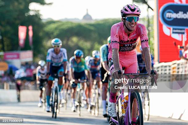 Team Visma-Lease a Bike's British rider Simon Yates wearing the pink jersey of overall leader celebrates as he crosses the finish line of the 21st...