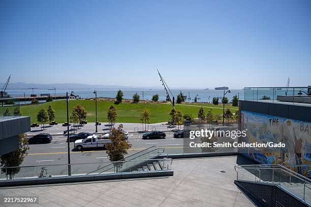 Elevated view of Bayfront Park, street traffic, and San Francisco Bay under clear sky, with colorful mosaic mural in foreground, Mission Bay, San...