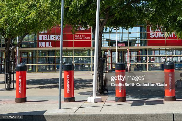 Exterior of Moscone Center with red Databricks AI Summit signage and branded safety bollards, San Francisco, California, May 27, 2025.
