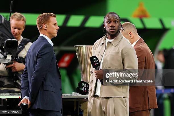 Pundits Michail Antonio and Steve Sidwell look on from a pitch side TNT sports TV set ahead of the UEFA Conference League Final 2025 between Real...