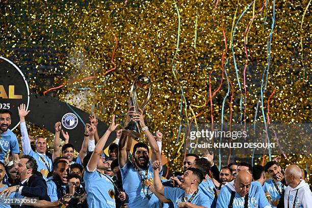 Pyramids' Egyptian defender Ahmed Samy raises the trophy as Pyramids' players celebrate winning the CAF Champions League final football match between...