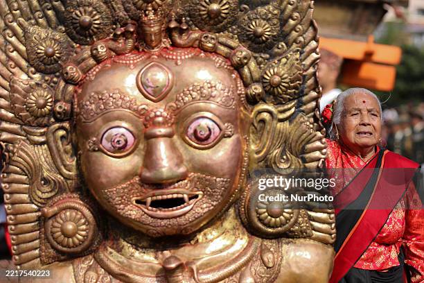An elderly woman performs rituals in front of the Rato Machhindranath chariot ahead of the Bhoto Jatra procession in Lalitpur, Nepal, on June 1,...