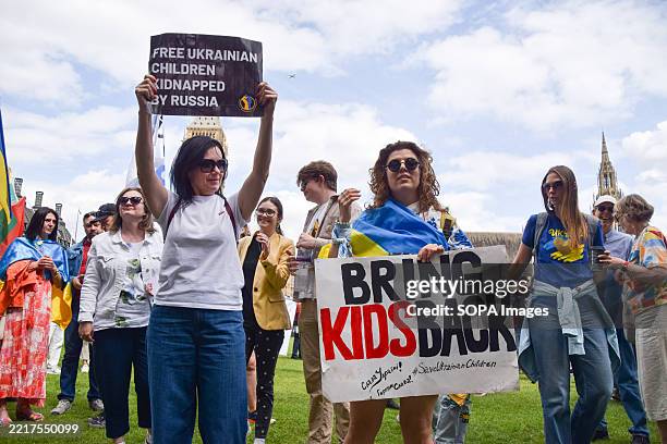Protesters hold placards during the demonstration in Parliament Square demanding the release of Ukrainian children kidnapped by Russia and an end to...
