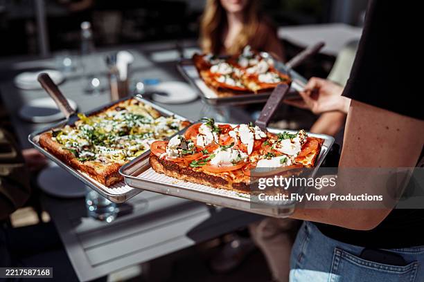 waitress serving pizza to guests - pizzeria stock pictures, royalty-free photos & images