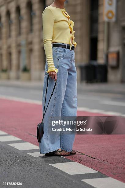 Patricia Wirschke is seen wearing a butter yellow longsleeve knit top with ruffles along the hem and the arm cuffs and adjustable front tie from...