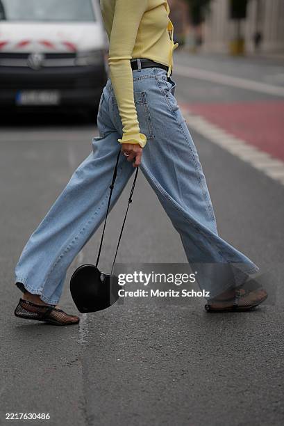 Patricia Wirschke is seen wearing a butter yellow longsleeve knit top with ruffles along the hem and the arm cuffs and adjustable front tie from...