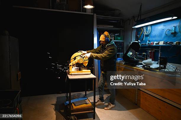 worker cutting metal with circular saw in workshop - resourceful stock pictures, royalty-free photos & images
