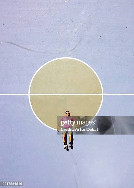 mind blowing creative drone shot playing with the perspective on a basketball court with pastel colors - höhenangst stock-fotos und bilder