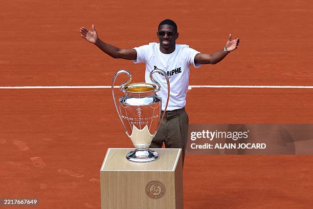 Paris Saint-Germain's French forward Ousmane Dembele brings the UEFA Champions League's trophy on Court Philippe-Chatrier as part of the French Open...