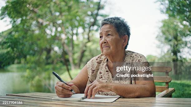 elderly woman writing in nature - old diary stock pictures, royalty-free photos & images