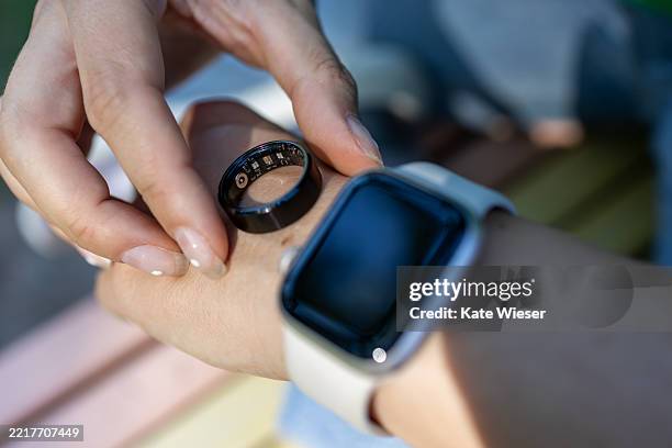 unrecognizable woman wearing smart ring. checking heart rate on smart watch - wearable stock-fotos und bilder